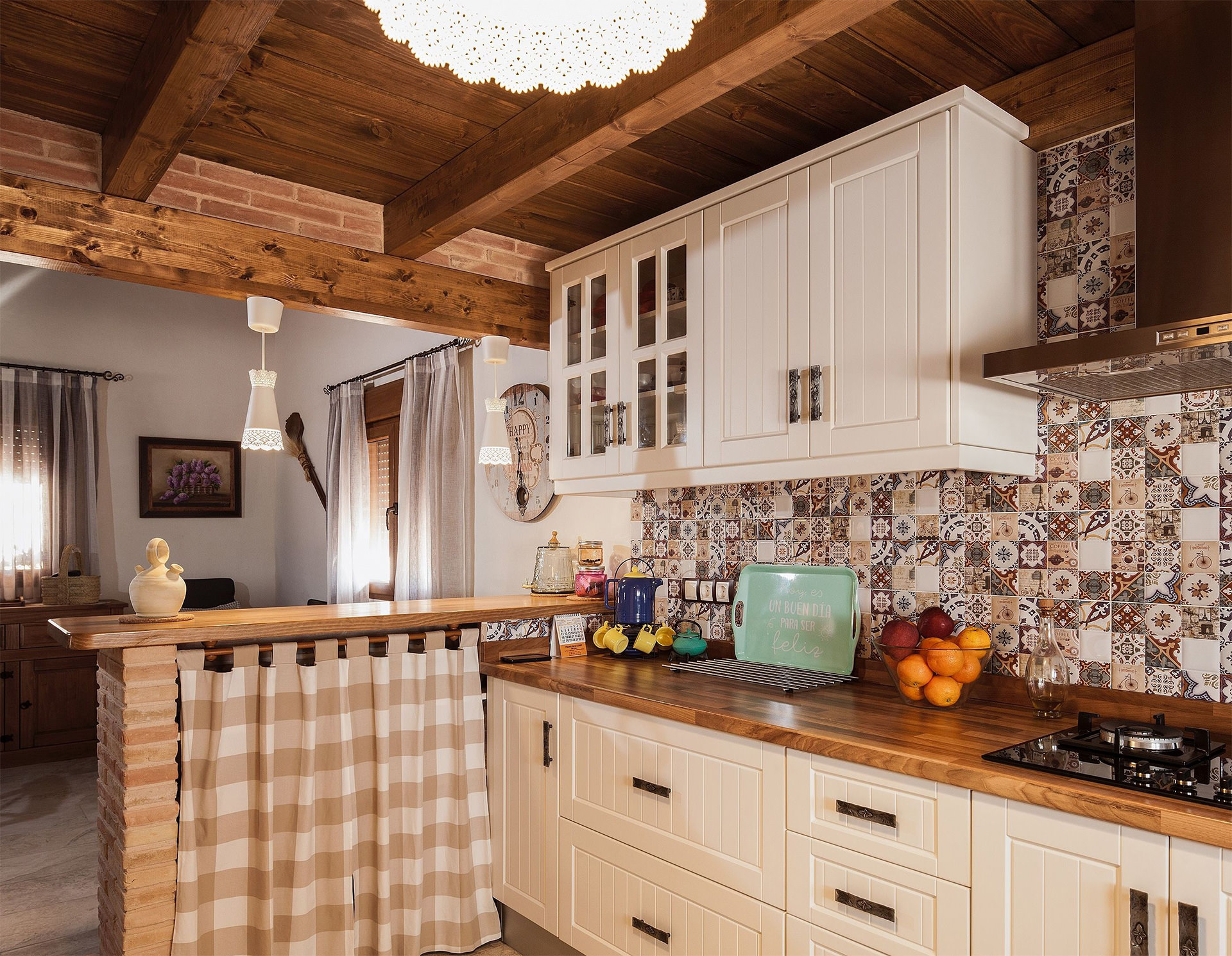 Vista desde interior de la cocina hacia el salón donde se ven los detalles del sus materiales, decoración e iluminación.