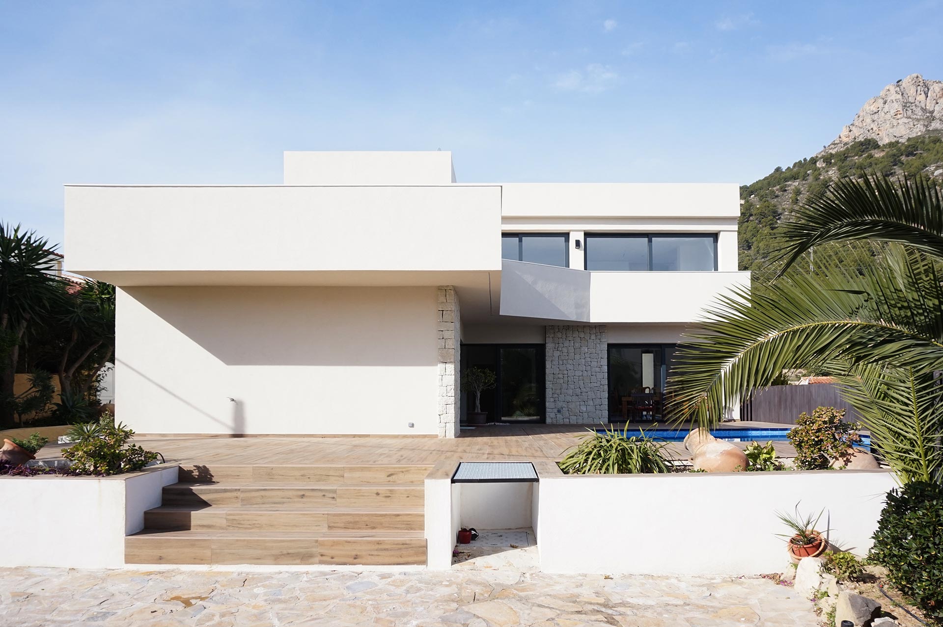 Exterior casa en desnivel, jardineras y voladizos.